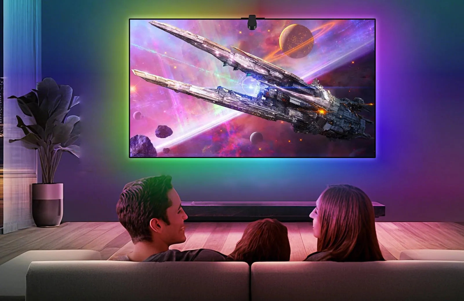 Couple watching a space film with matching purple and teal light on the wall